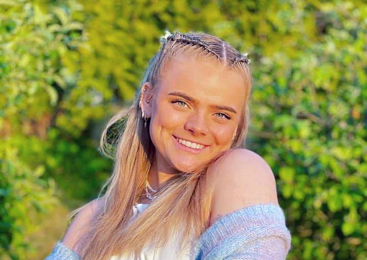 Linnea Løtvedt smilende foran en grønn hage
