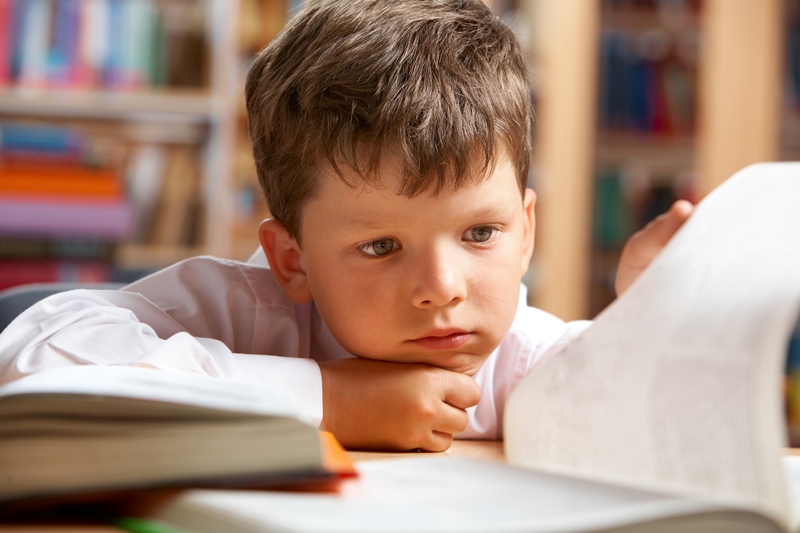 Ettertenksom gutt blar i skolebok