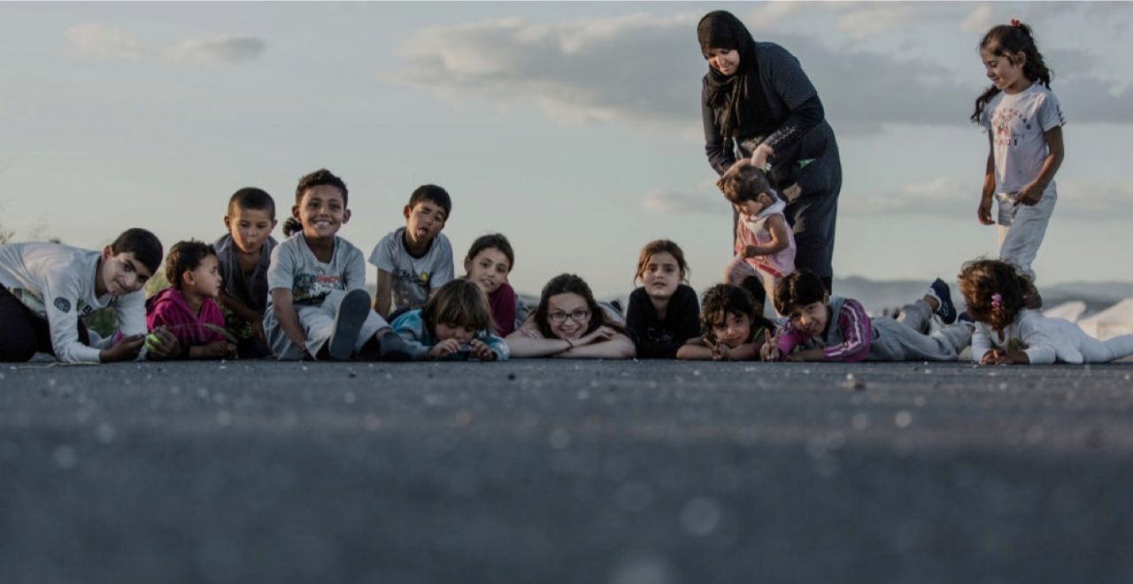 Smilende barn og en voksen